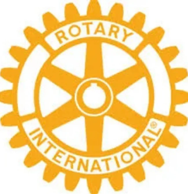 The official Rotary International logo, featuring a yellow and white cogwheel design.
